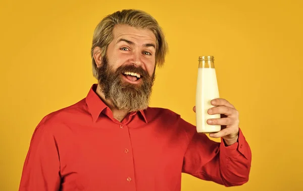 Lactose-intolerantie. De man met de baard houdt de melkfles vast. Gepasteuriseerde melk. Veganistisch melkconcept. Drink proteïne cocktail. Gezonde gewoonten. Maak planten melk thuis. Winkelreclame. Hoe zuivelvrij te zijn — Stockfoto