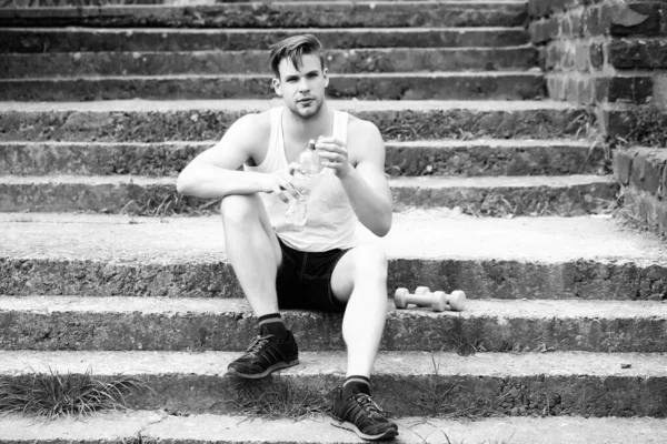 Esportista com rosto sério sentado em escadas de concreto — Fotografia de Stock