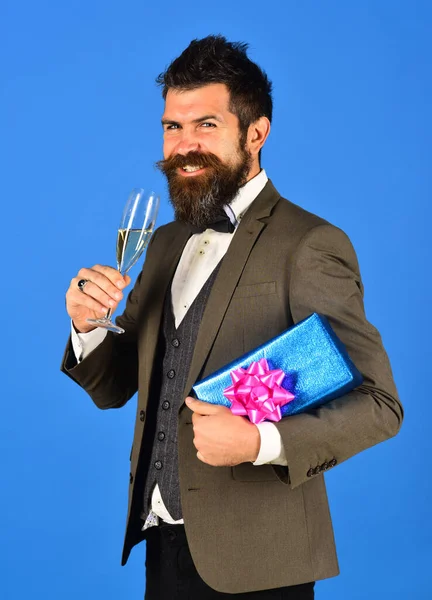 Cheerful bearded businessman standing with present — Stock Photo, Image