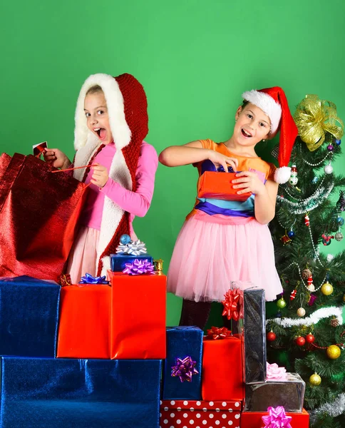 Hermanas en Santa Claus sombreros con cajas de regalo regalos abiertos. —  Fotos de Stock