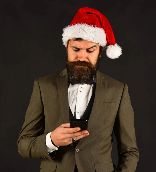 Чоловік у розумному костюмі та капелюсі Санта на коричневому фоні — стокове фото
