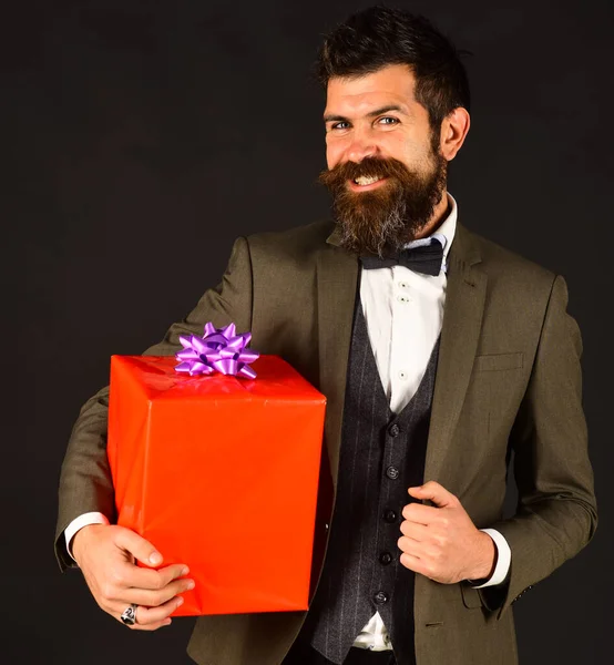 Biznesmen ze szczęśliwą uśmiechniętą twarzą i czerwonym pudełkiem prezentów — Zdjęcie stockowe