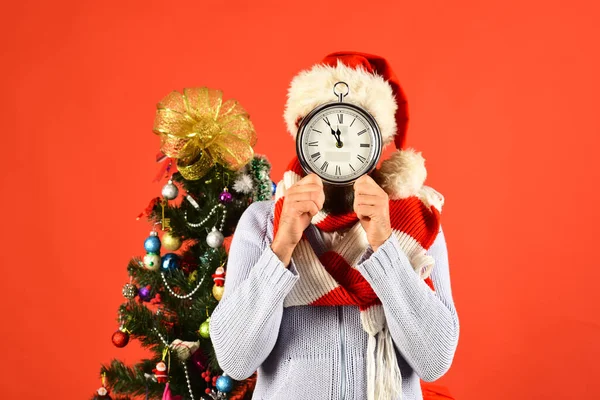 산타는 장식 된 전나무 근처에 있습니다. 큰 알람 시계를 들고 있는 남자 — 스톡 사진