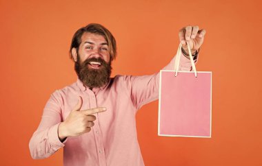 Giden adam ürünü seçiyor. Hediyeli mutlu sakallı adam. Vahşi hippi hediyeleri. Kağıt alışveriş torbası. Partide doğum günü sürprizi. Paketli adam. Tatil için hazırlanın. en iyi satış teklifi