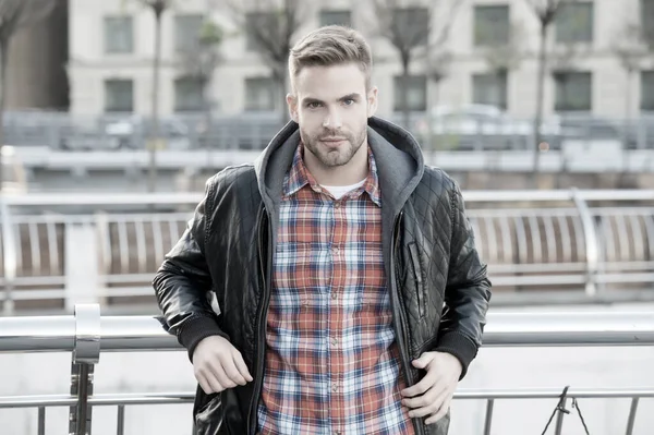 Fresco y seguro. Concepto de cuidado facial del cabello y la piel. Bonita cara. Hombre guapo sin afeitar la cara y el pelo elegante. Hombre caucásico de fondo urbano. Chaqueta de piel de hombre barbudo. Guapo chico retrato — Foto de Stock