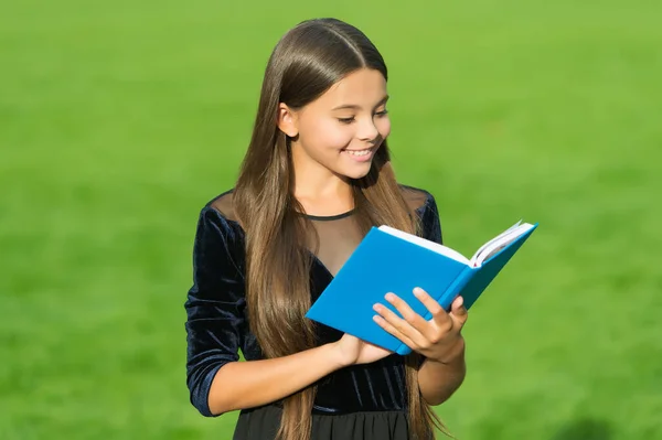 Zihni besle. Mutlu çocuk kütüphane kitabı okur. Şirin kitap kurdu yeşil çimenleri inceliyor. Okul kütüphanesi. Okuma ve okur yazarlık eğitimi. Bibliotheca. Edebiyat dersi. Bilgi susuzluğunu giderir. — Stok fotoğraf