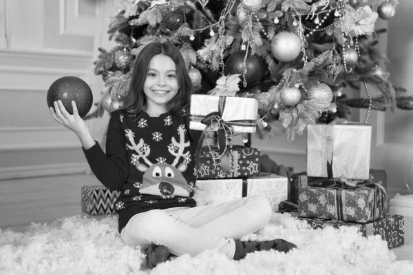 これを見てみろ。クリスマスツリーの近くの女の子。子供は家でクリスマスを祝う。冬の伝統。ギフトショップのコンセプト。愛らしい興奮した子供はクリスマスセーターを着ています。クリスマスの属性の装飾 — ストック写真