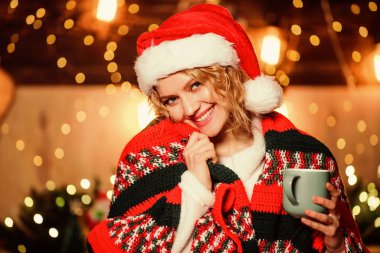 Sabah kahvesinin tadını çıkarıyor. Kız Noel Baba şapkalı süt bardağı. Neşeli kadın kendini rahat hissediyor kutlama zamanı. Mutlu yıllar. Noel zamanı. Xmas havası. Kadın kakao içiyor. Kış tatili sabah kahvesi