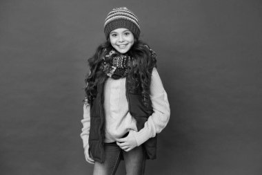 Temiz hava için modaya uygun kıyafetler. Moda tarzı kırmızı arka planda mutlu bir kız. Küçük çocuğun modaya uygun görünüşü. Kış tarzı. Moda ve güzellik. Modaya uygun ve zarif.