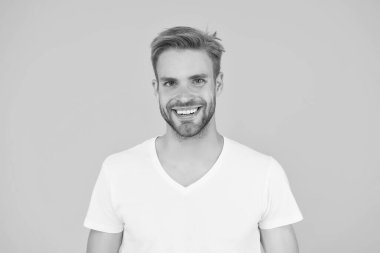 Yakışıklı, seksi adam. Karizma konsepti. Yüz bakımı. Güzel insanlar. Yakışıklı genç adam. Tıraşsız yakışıklı bir adam. Tüylü hippi beyaz tişört giyer. Yakışıklı adam poz veriyor. Karizmatik maço