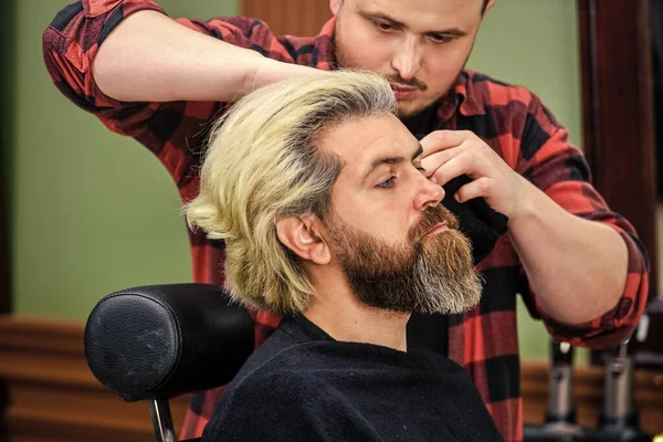 Date un'occhiata accattivante. maturo bell'uomo con i capelli lunghi. strumento barbiere o parrucchiere. hipster al barbiere. cliente barbuto dal parrucchiere. E 'ora di tagliarsi i capelli. uomo guarda specchio riflesso — Foto Stock