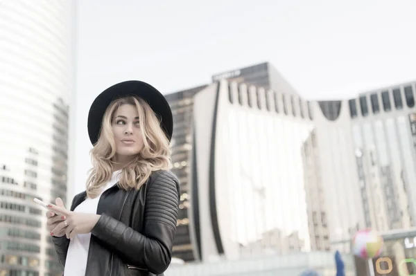 Modelo de belleza con smartphone de moda en París, Francia. Mujer sensual con pelo largo y rubio, peinado, belleza. Moda, estilo, accesorio. Juventud, cuidado de la piel, rostro. Belleza, mira, maquillaje — Foto de Stock