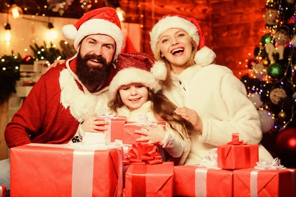 明けましておめでとうございます。冬休みだ。買い物の販売。メリー・クリスマス。父と母は娘を愛する。サンタ・ハットの小さな子供と両親。クリスマスプレゼント箱。プレゼントを開けなさい。幸せな家族は新年を祝う — ストック写真