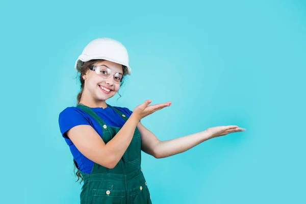 将来のエンジニアが製品を発表します。修理用のセーフティグラスを身に着けてる幸せな子供。建設現場だ。子供建築家労働者。労働者の日。幼児期の発達。ティーンガールアシスタント — ストック写真
