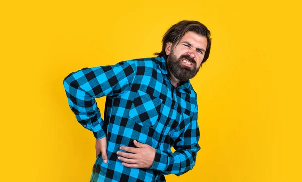 Bearded man in checkered shirt. brutal guy with emotional face. unhappy handsome hipster has backache. mature man has moustache. feel the pain — Stock Photo, Image