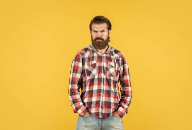 Kendine güvenen ve şık. Dama gömlekli, kendinden emin ve katı bir adam. Ekose gömlekli olgun sakallı adam. Sarı arka planda kareli gömlek giyen yakışıklı bir adam. Erkek güzelliği ve moda