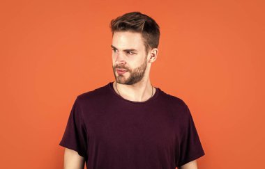 Yüz bakımı. Stüdyoda poz veren mor elbiseli seksi adam. Kentli tişörtlü, kendine güvenen genç bir adam. Kot modası. Sakallı yakışıklı adam. Genç traşsız adam