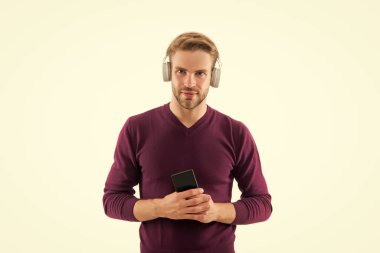 Cep telefonundaki müzik parçalarını değiştir. Kendine güvenen adam mp3 çalarda çalma listesi açıyor. Karizmatik müzik aşığı. Beyaz tenli yakışıklı, tıraşsız bir adam. Kulaklıkla müzik dinle.