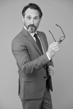 Sakallı ve gözlüklü adam kendine güveniyor. Takım elbiseli bir iş adamı. Yakışıklı, kendinden emin iş adamı portresi. Gözlüklü orta yaşlı bir adam. Zeki ve zeki görünüyor. Saf duygu.