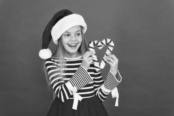 Grappige feesttijd. Zoet kindergeluk. Een klein meisje die plezier heeft. Kerstman kind snoepgoed decoratie. kerstvakantie decoratie. Kerstinkopen doen. Gelukkig nieuwjaar. feestelijk feest in rode kleur — Stockfoto