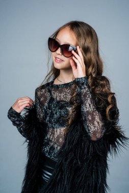 Uzun kıvırcık saçlı genç kız moda güneş gözlüğü takıyor, güzellik