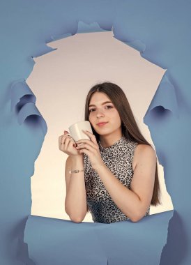 Güzel kız çay fincanını tutar. Sıcak içecek içmek. Genç çocuklar kakao içer. Kahve fincanı olan çocuk. Günaydın. Sabah ferahlatıcı ve enerji içeceği konsepti. ılık süt