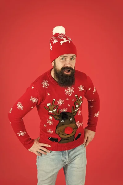 Bonne année concept. Rejoignez la fête. La veille de Noël. Tenue d'hiver. Bonnes vibrations. Activités intérieures préférées de la saison hivernale. Hipster homme barbu porter pull d'hiver et chapeau fond rouge — Photo