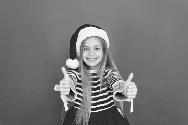 Найкращі побажання. Радісна дитина. Дитячий костюм Санти вірить у диво. Дівчинка на червоному тлі. З Різдвом і Новим роком. Різдвяна вечірка. Весела дівчина веселиться напередодні Різдва — стокове фото