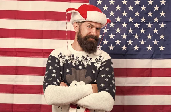 Brutal man wear knitted sweater. American tradition. Bearded hipster american flag background. Xmas new year. Spirit of patriotism. Christmas tradition from united states of America. American customs