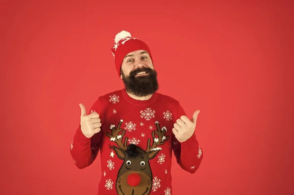 Atividades divertidas e coisas para fazer. Hipster homem barbudo emocional usar camisola de inverno e chapéu fundo vermelho. Feliz ano novo conceito. Junte-se a festa de inverno. Festa de camisola de Natal. Roupa de inverno — Fotografia de Stock