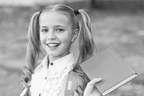 Book is uniquely portable magic. Happy schoolgirl hold book outdoors. Little reader. School library. Literature study. Reading habit. Book shop. Education and knowledge. Book you cant resist — Stock Photo, Image