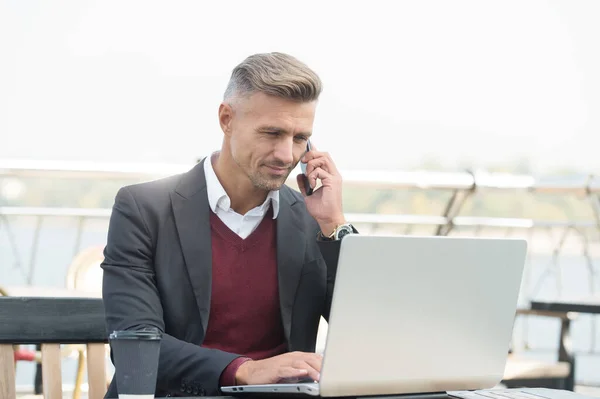 Commercieel medewerker maken telefoongesprek werken op laptop in internet cafe buiten, conferentie — Stockfoto