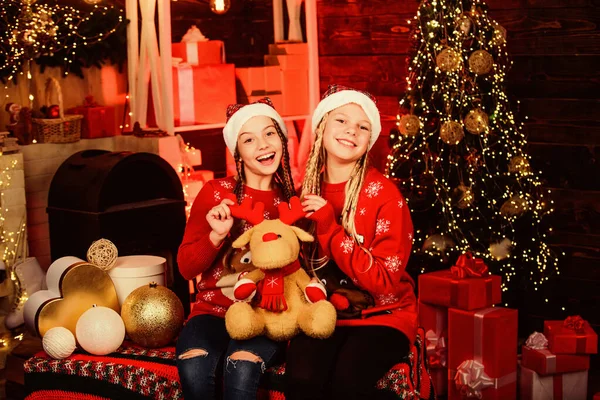 Vacaciones de diciembre. Vacaciones y vacaciones. Felices fiestas. Niños divirtiéndose en Nochebuena. Felicidad alegría. Valores familiares. Concepto de hermandad. Chicas amigas hermanas Santa Claus trajes. Niños juguetones — Foto de Stock