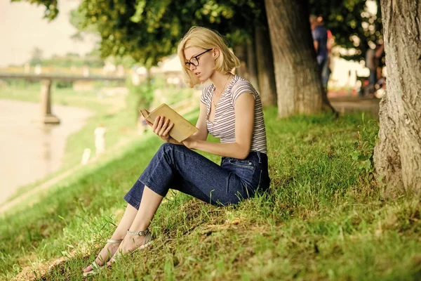 Descanse e passatempo. Uma mulher a sonhar com férias. Férias. Estudante nerd inteligente sentar na grama verde e ler livro. Literatura para férias de verão. Menina relaxante na beira do rio após o dia de trabalho — Fotografia de Stock