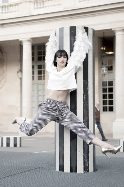 La mujer cuelga de la columna en París, Francia. Mujer con labios rojos maquillaje y cabello moreno —  Fotos de Stock