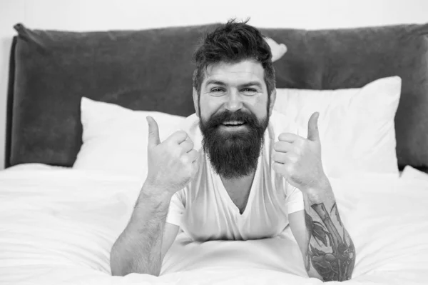 早上是新的开始。快乐的人举起大拇指。留胡子的男人在床上休息.有胡子和胡子的白人男子。粗野的男人带着时髦的发型笑着.核定数 — 图库照片
