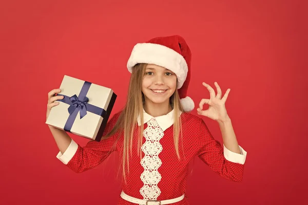 Kleines Mädchen Eröffnungsgeschenk. Neues Jahr. Weihnachtsmann-Geschenk. Das kleine Mädchen bekam ein Geschenk. Weihnachtsgeschenke. Tag des Boxens. Fröhliches Kind roten Hintergrund. Adventskalender. Überrascht sie. Frohe Winterferien — Stockfoto