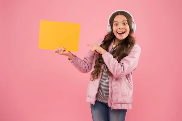 L'avez-vous vu ? enfant pointant du doigt sur le papier pour l'espace de copie. éducation en ligne annonce. technologie publicitaire. développement de l'enfance. enfant heureux dans écouteurs écouter de la musique. retour à l'école — Photo