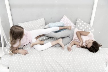 Birlikte eğleniyoruz. Uyumadan önce eğlence. En iyi arkadaşlar. Kız kardeşler yatakta oynuyor. Tatlı rüyalar. Yatak odasında pijama partisi. çocukluk mutluluğu. Çocuklar arkadaşlığı. Mutlu küçük kızlar. Günaydın.