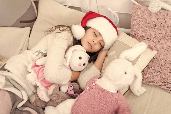 마법의 아침이야. 크리스마스 이브 컨셉이야. 집이 참 좋네요. 크리스마스 장식을 하고 침대의 불빛 속에서 쉬고 있는 꼬마 소녀. 아늑 한 방. 어린 아이는 침실에서 휴식을 취한다. 긴장을 풀고 누워 있는 아이 — 스톡 사진