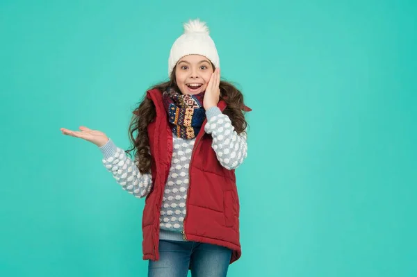 Överraskad tonåring flicka med långa lockigt hår bära puffer väst och stickade kläder på jul semester presentera produkt, kopiera utrymme, vinter shopping försäljning — Stockfoto