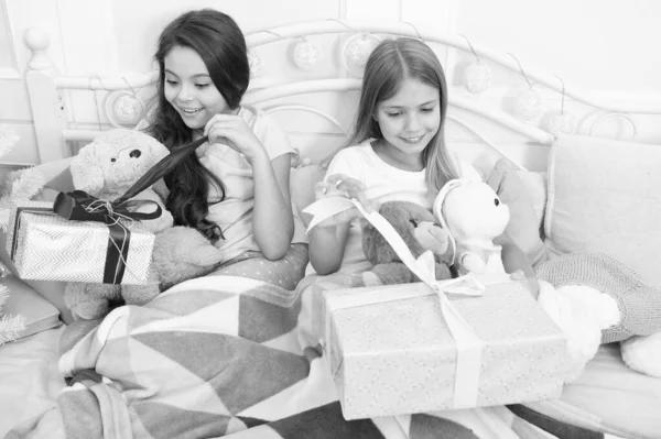 Es hora de celebrar. Regalos de apertura en la mañana de Navidad. Los niños pequeños felices sostienen cajas de regalo. Adorables niñas pequeñas con regalos en la cama. Feliz Navidad y Feliz Año Nuevo. Sorpresa de Año Nuevo — Foto de Stock
