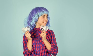 Partideki çocuk. kopyalama alanı. Küçük mavi peruklu kız dekoratif kalp taşıyor. Sevgililer günün kutlu olsun. Valentine 'dan güzel bir hediye. Tatil için hediye alışverişi. Kalp aşkın sembolüdür. Çocuk romantik havasında.