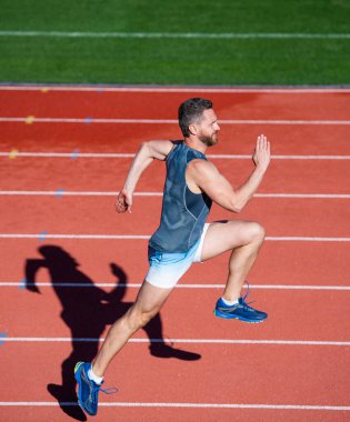 İlk ol. Spor, sağlıklı yaşam tarzı. Spor salonu açık havada. Koşucu pistte hızlı koşar. Enerjik ve sportif. Maraton hız enerjisi. Kaslı adam hareket halinde. Sporcu adam sprint 'te yarışıyor.