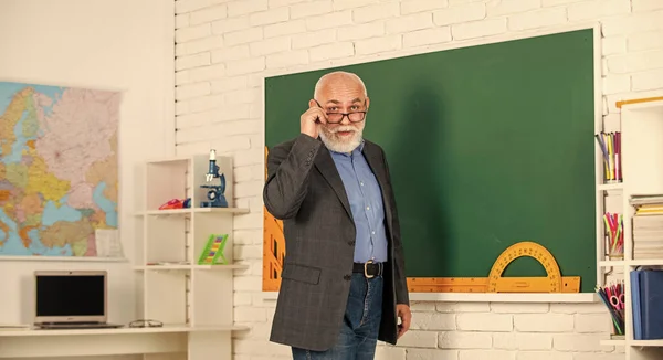 De vuelta a la escuela. Profesor de la vieja generación escolar. Profesor experimentado. Hombre maduro disfrutando del trabajo. El maestro va a seguir asumiendo nuevos roles y responsabilidades. Profesor sénior en pizarra —  Fotos de Stock