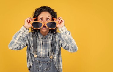 Komik parti gözlüğü takan mutlu ve şaşırmış genç bir kadın. Olumlu haberlerle müjdelenirler. Esmer, komik beyaz kadın portresi. Sadece eğleniyorum. kız mutluluğu hissediyor