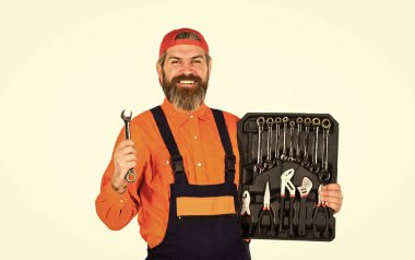 Profesyonel ekipmanlar. Gerçekten iyi aletler. Araç gereç kutunda ne taşıyacaksın? Üniformalı adam beyaz arka plan taşıyor. Tamirci tamirci, alet çantası taşıyan tamirci. Becerikli adam kavramı