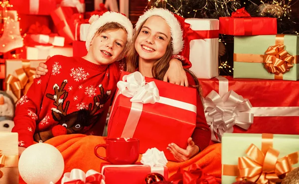 Small kids friends have fun. santa helpers among red present boxes. too much gifts. online shopping. childhood happiness and carefree. family values for children. cosy winter evening together — Stock Photo, Image