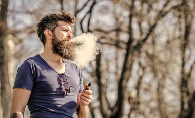 Stres atma konsepti. Tüttüren sakallı adam. Beyaz aromalı duman bulutları. Elektronik sigara içiyorum. Uzun sakallı adam sigara içmekten rahatlamış. Sakallı ve bıyıklı adam nefes ver.