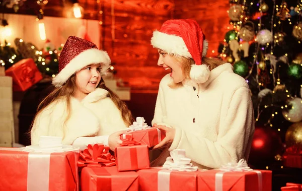 Önskar ett gott nytt år. liten flicka med mamma i tomte hatt. God jul, då. Mamma och dotter älskar semestrar. Vintershopping försäljning. Jullådor. Öppna nu. Glad familj firar nytt år — Stockfoto